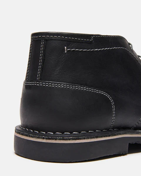 Harken black leather ankle boot close-up of side panel, stitching, and rubber sole edge.