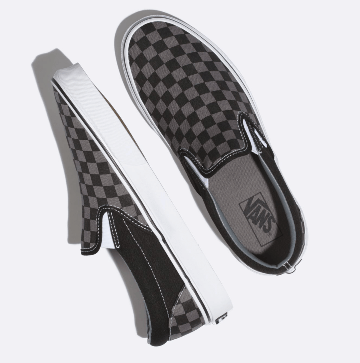 Black checkerboard slip-on Vans sneakers shown from side with white sole