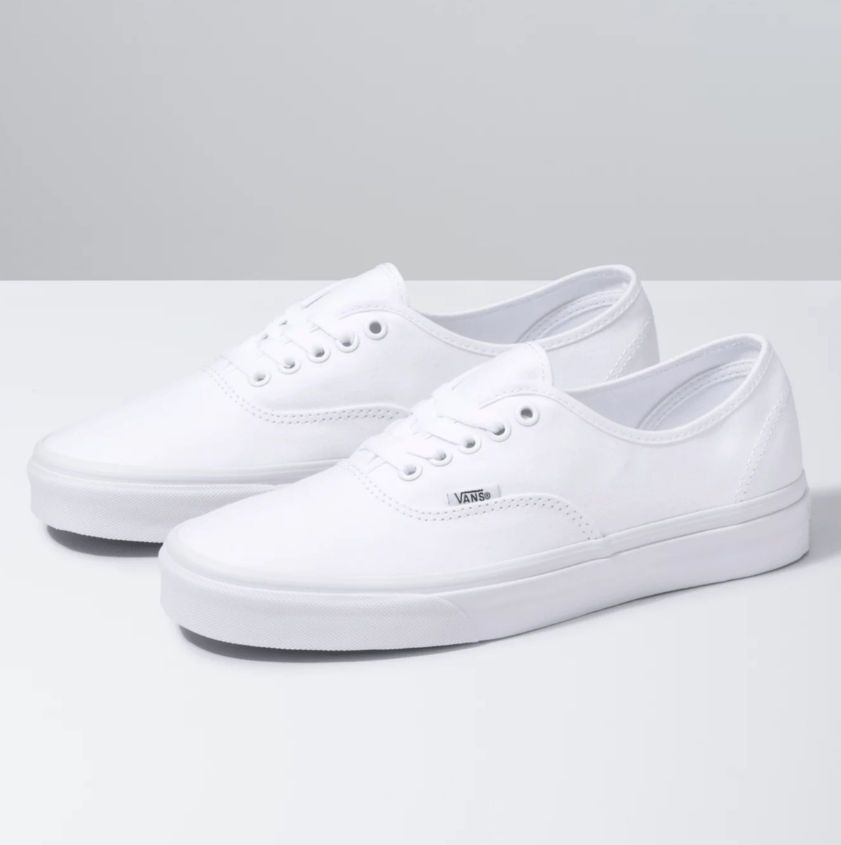 Pair of white lace-up low-top sneakers with side stripe stitching