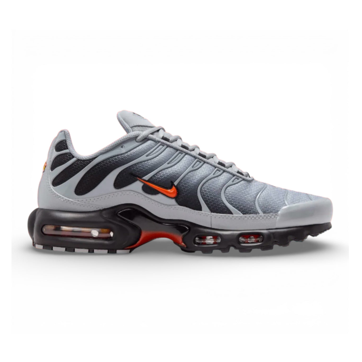 NIKE Air Max Plus sneaker in wolf grey with black and orange accents, side view.