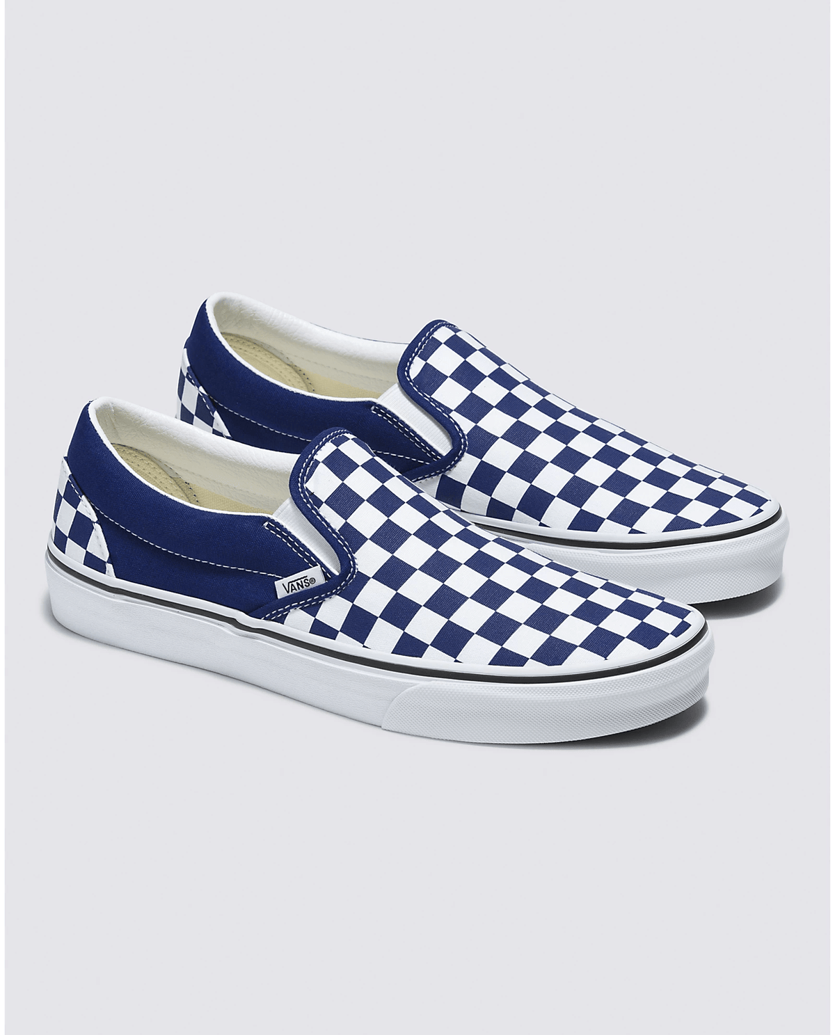 Pair of blue and white checkerboard slip-on sneakers with low-profile sole