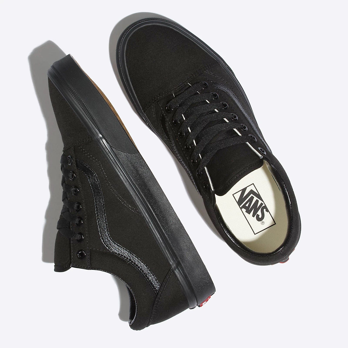Black low-top sneakers with black laces and Vans logo patch on the insole