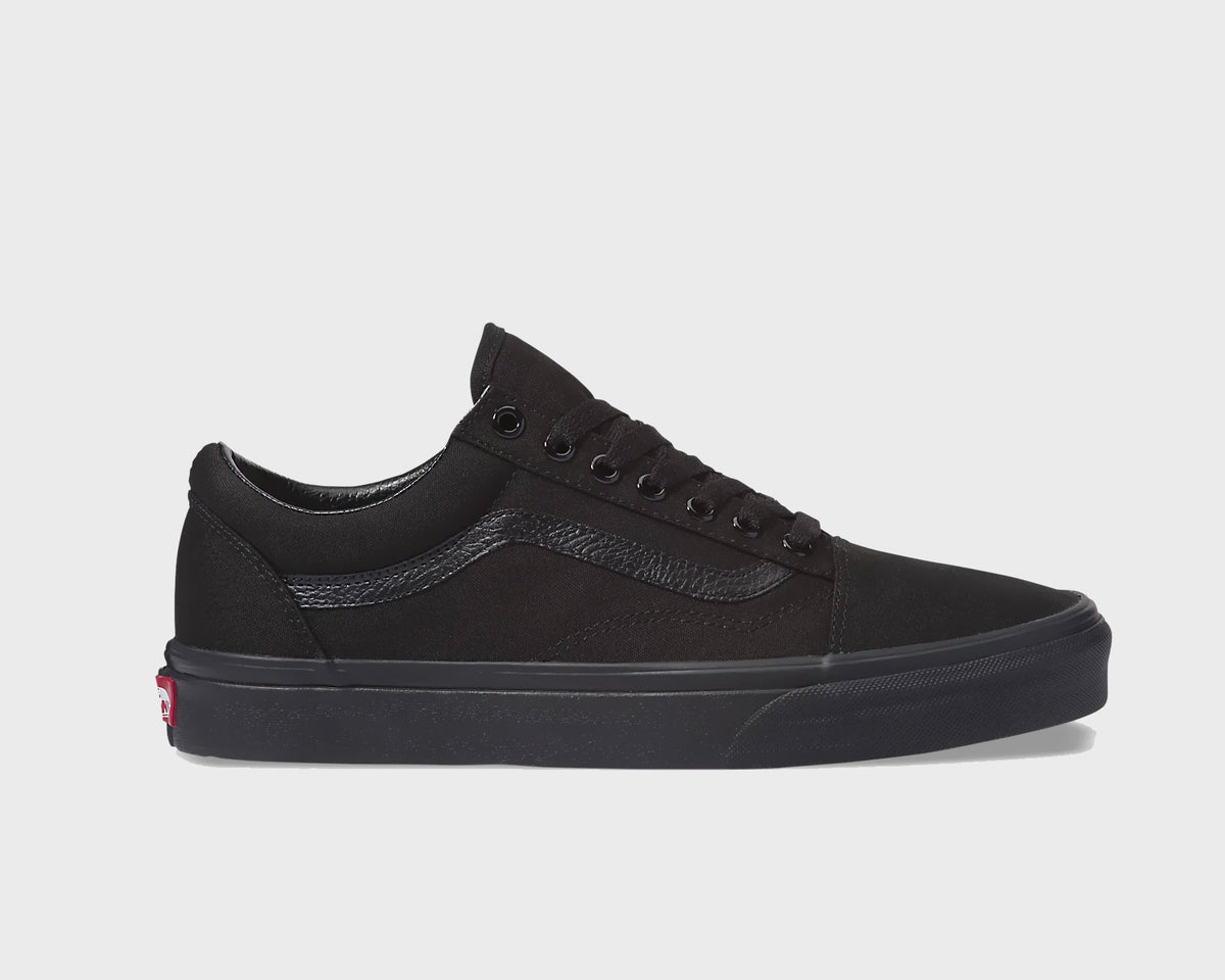 All-black low-top sneakers with lace-up front, dark side stripe, and rubber sole