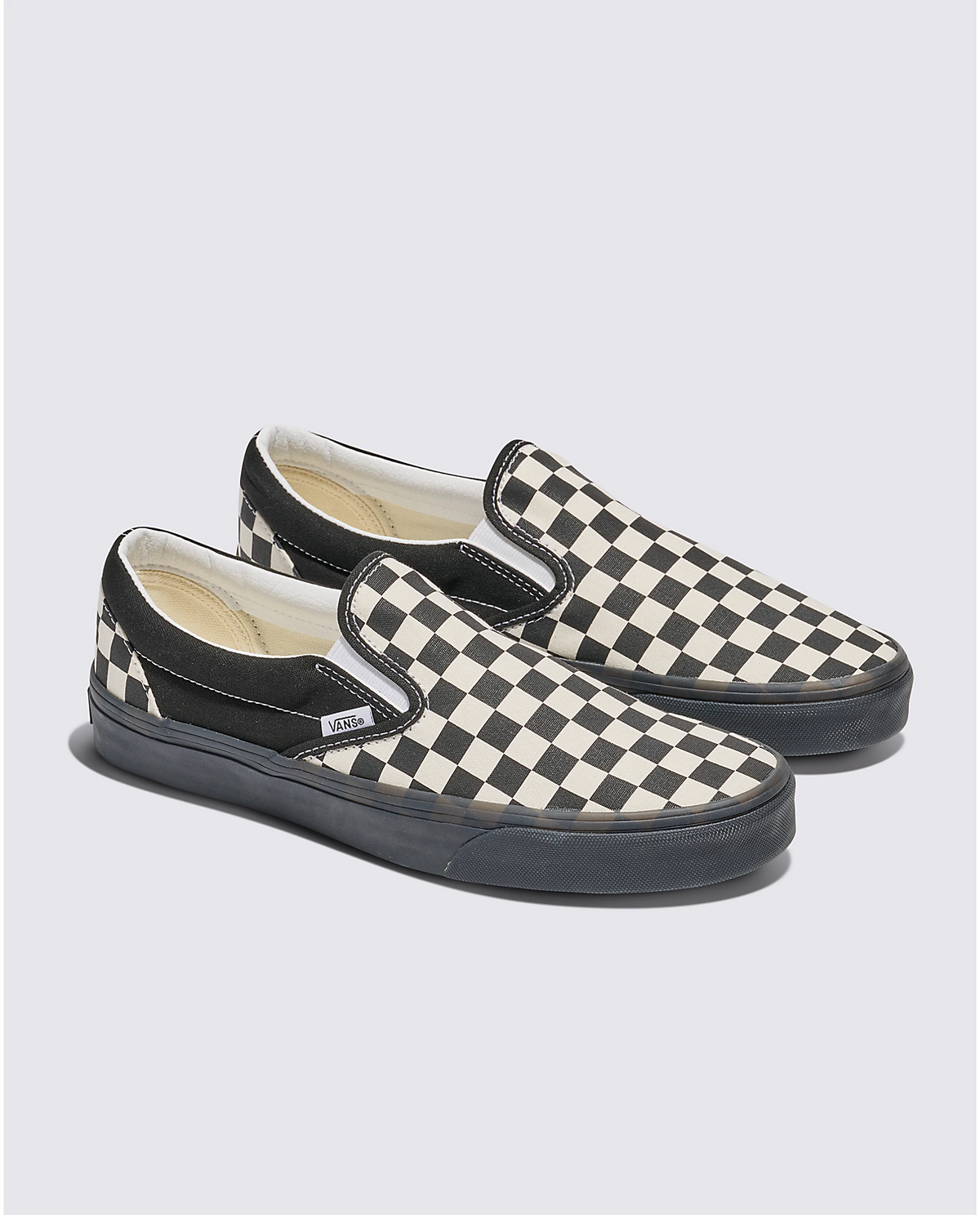 Two black-and-white checkerboard slip-on sneakers shown from side angles.