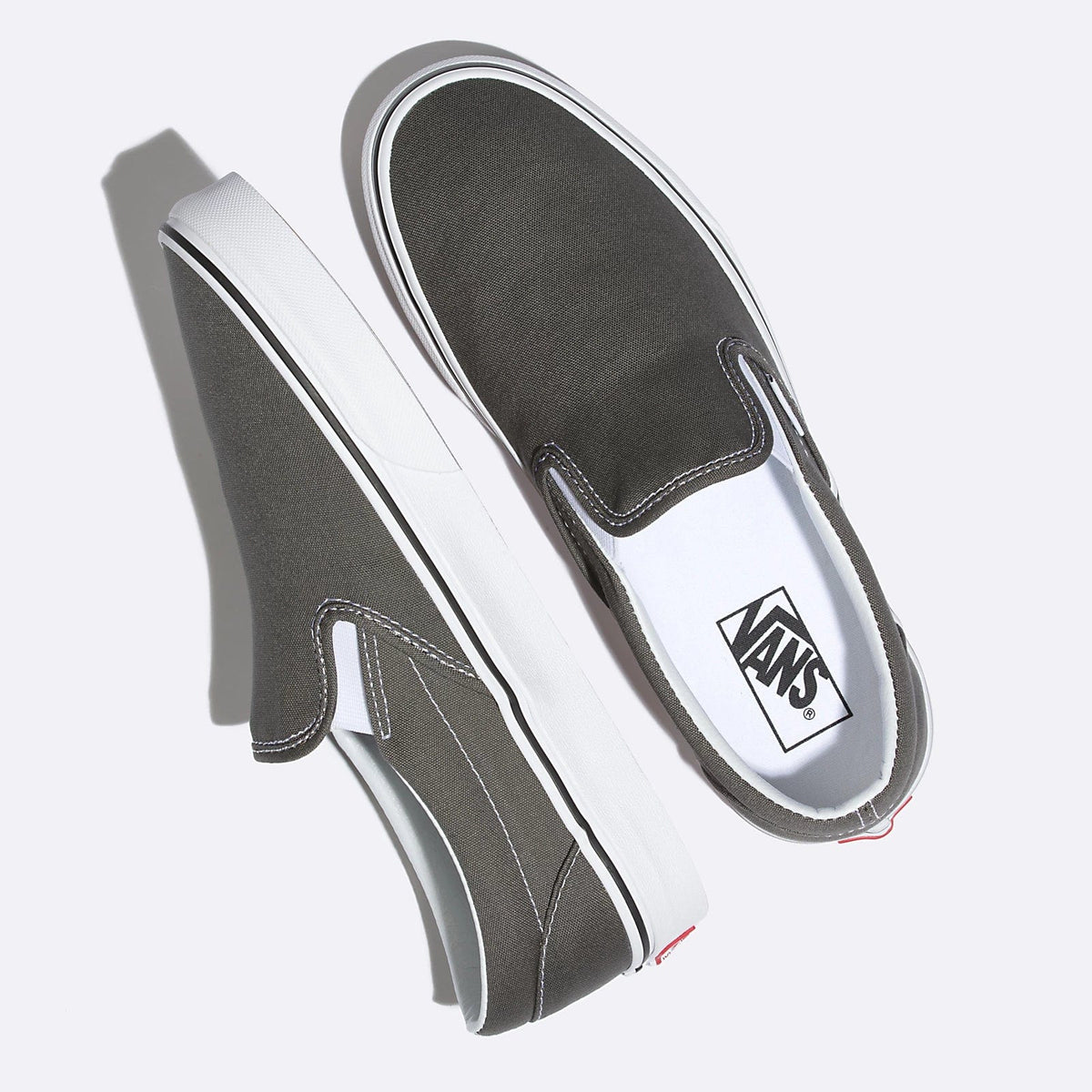 Charcoal slip-on sneakers, angled top view, with Vans logo patch
