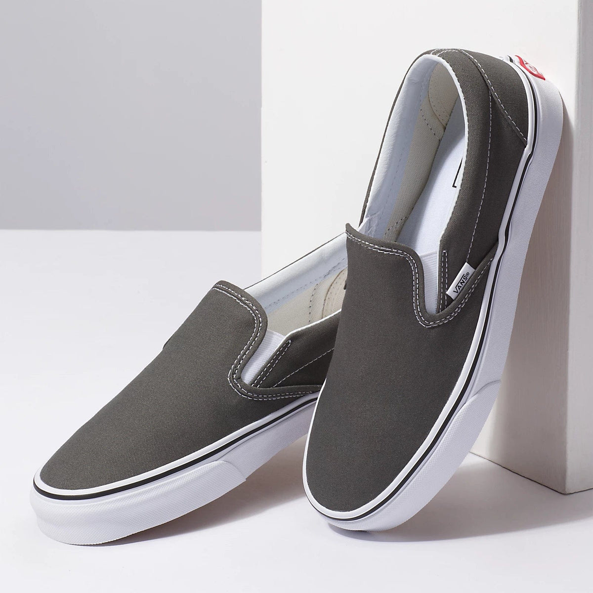 Charcoal slip-on canvas sneakers, front and side angles, with white sole