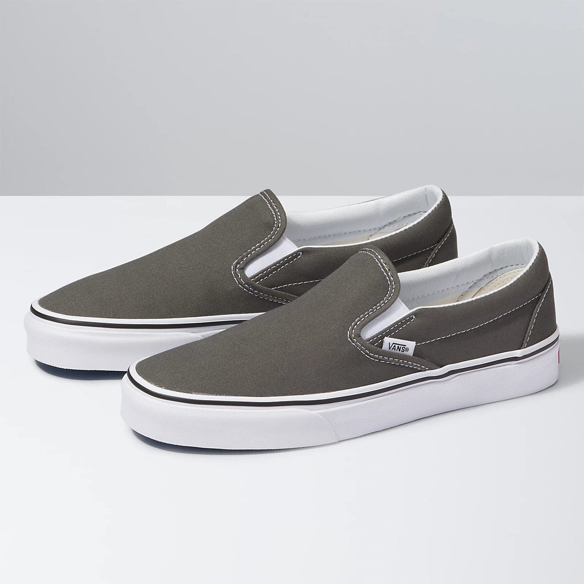 Charcoal slip-on sneakers pair, side view, with white rubber midsole