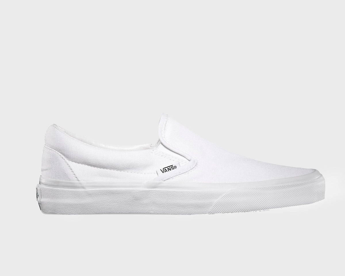 White canvas slip-on sneakers with Vans logo patch and low profile rubber sole