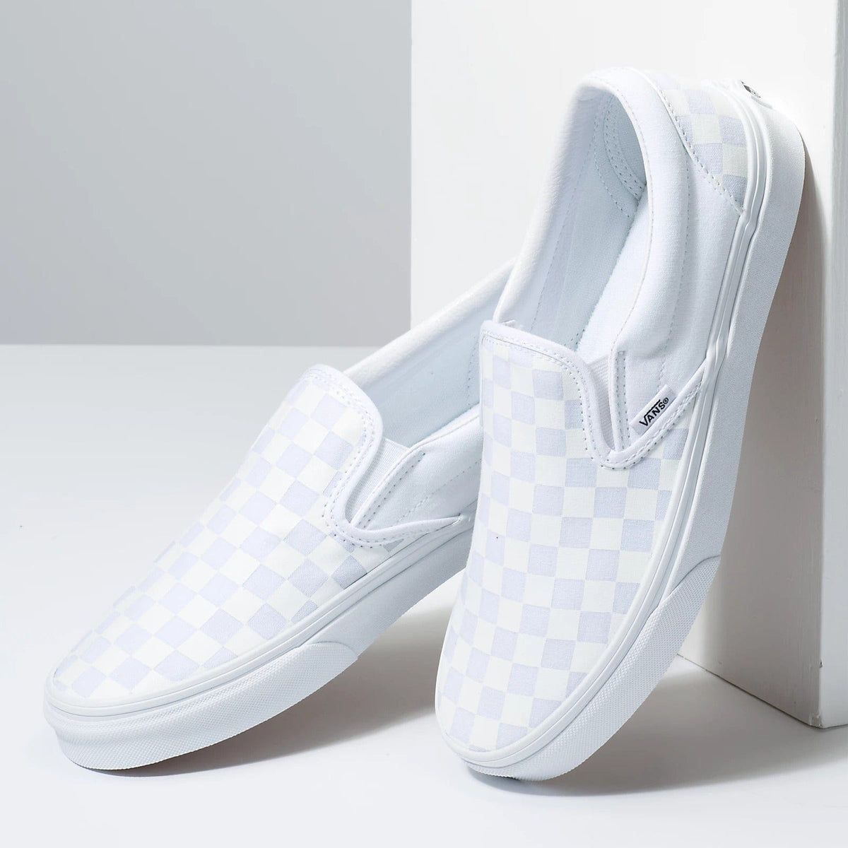 Light blue checkered slip-on Vans sneakers with padded tongue and white rubber sole