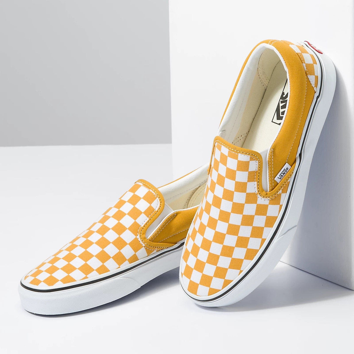 Checkerboard slip-on shoes with yellow panels and white orange check print, Vans.