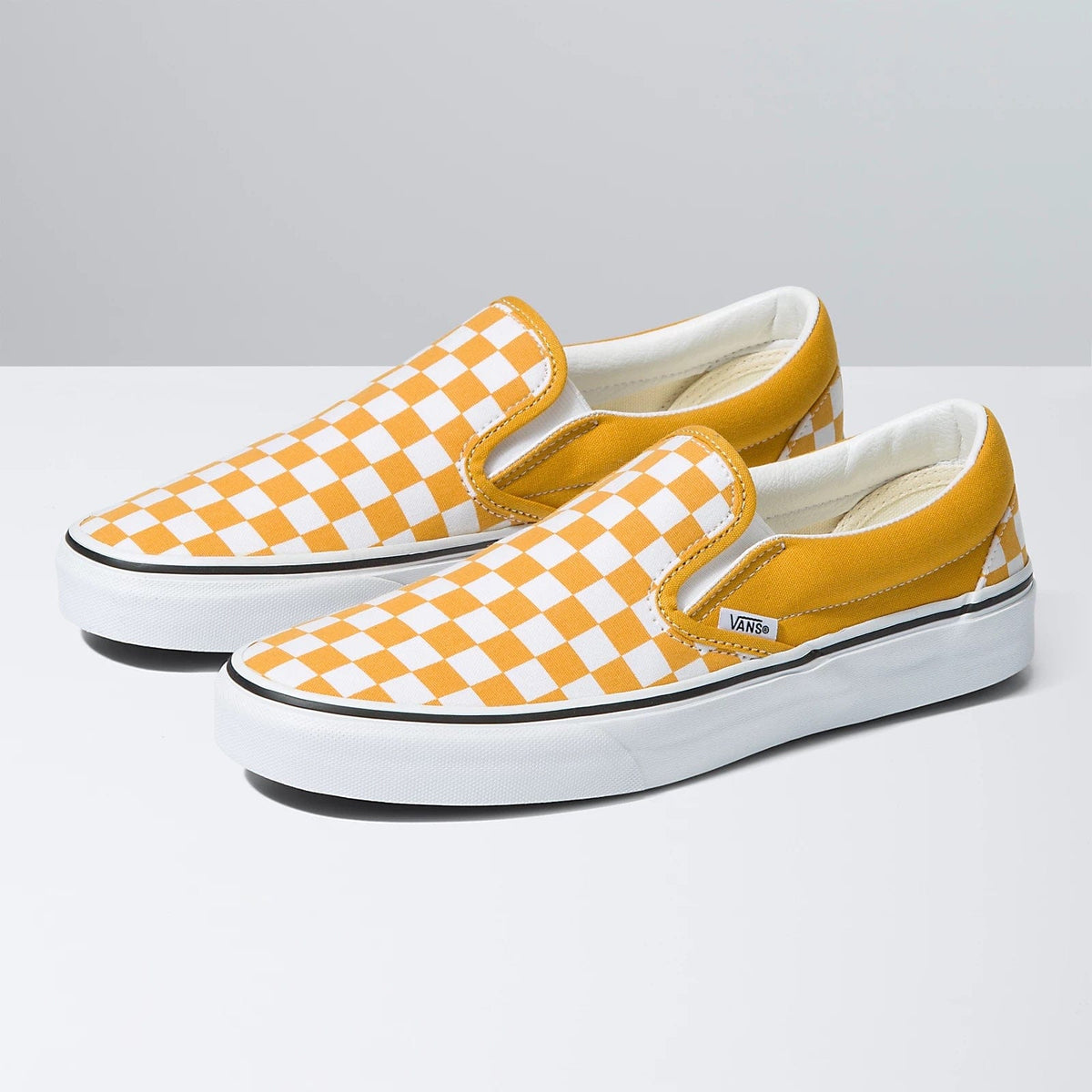 Checkerboard slip-on shoes, front view, orange/white check uppers with Vans tag.
