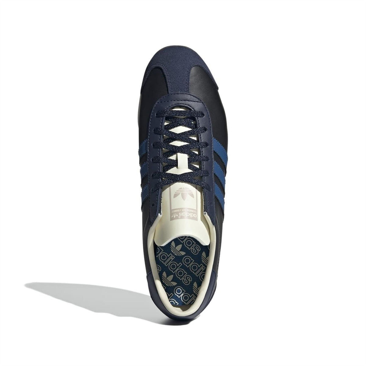 Low-top sneakers front view with navy laces and cream tongue patch