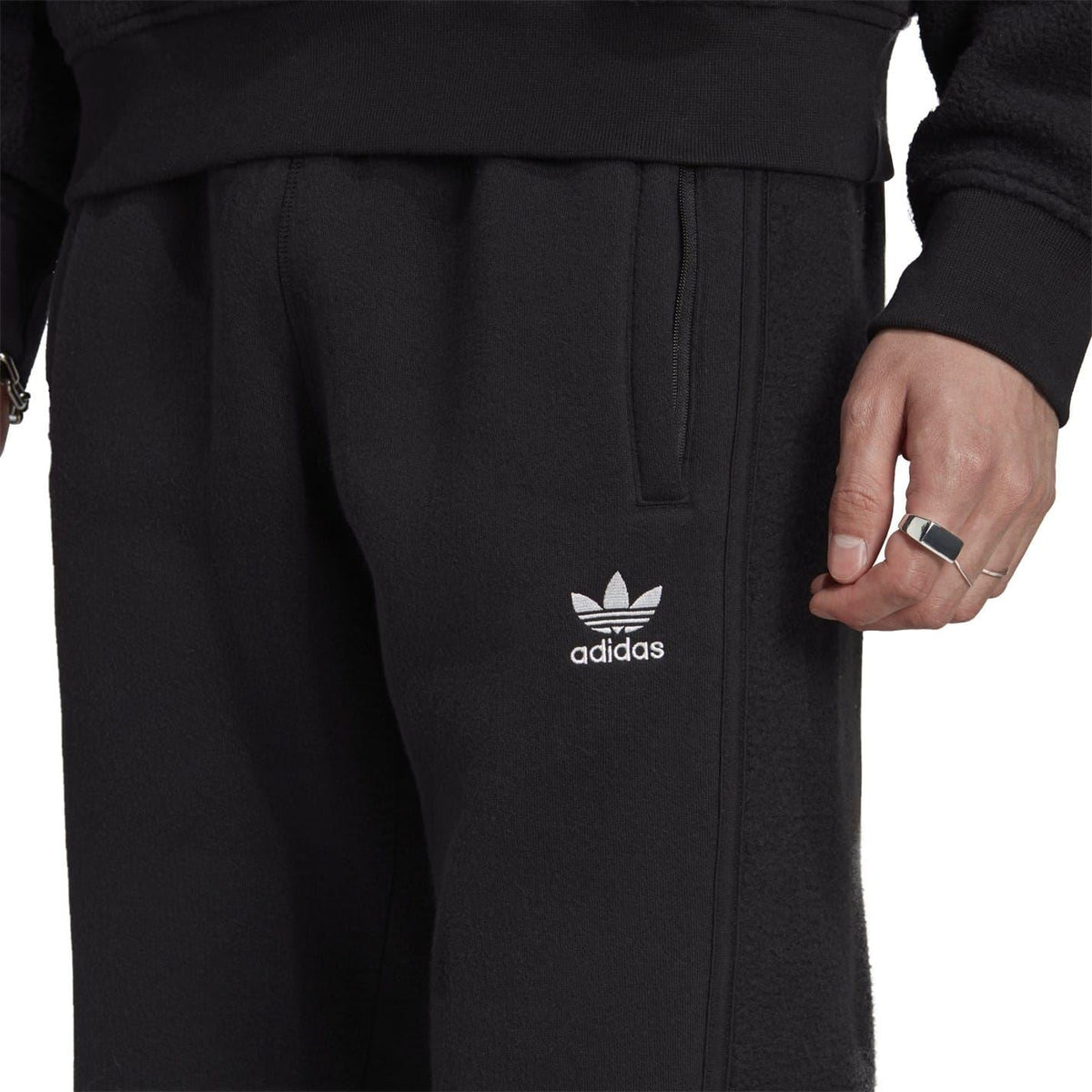 Black joggers showing adidas logo at hip and vertical seam details