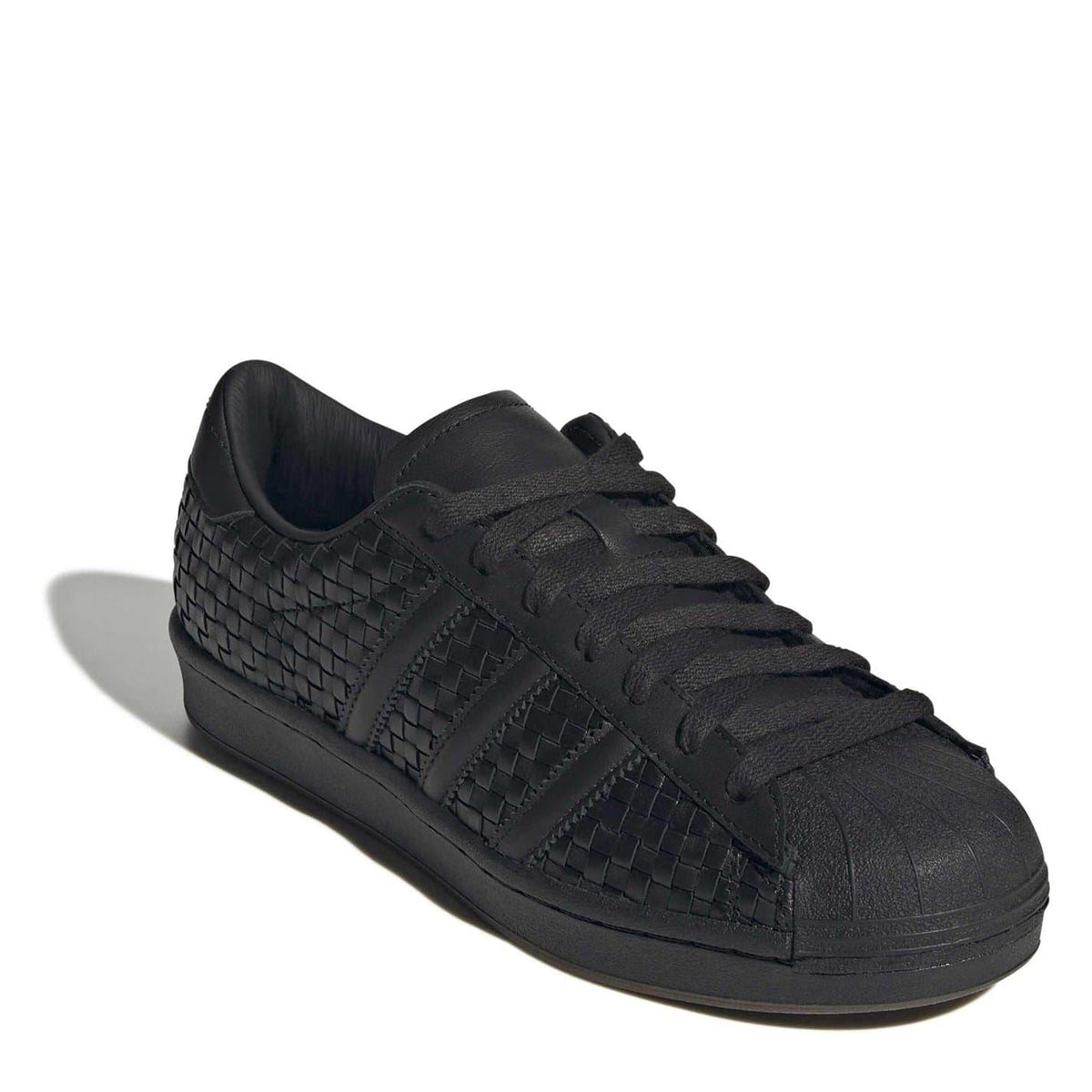 Black low-top sneakers with shell toe, lace-up front and embossed side stripe detail