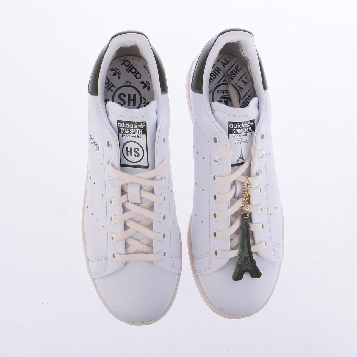 Pair of white high-top sneakers with lace-up closure and printed insoles
