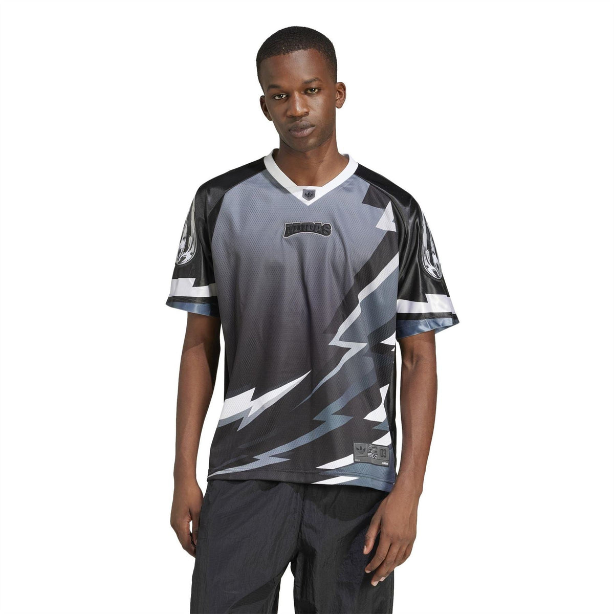Black and gray team jersey with white lightning print, V-neck, worn by model