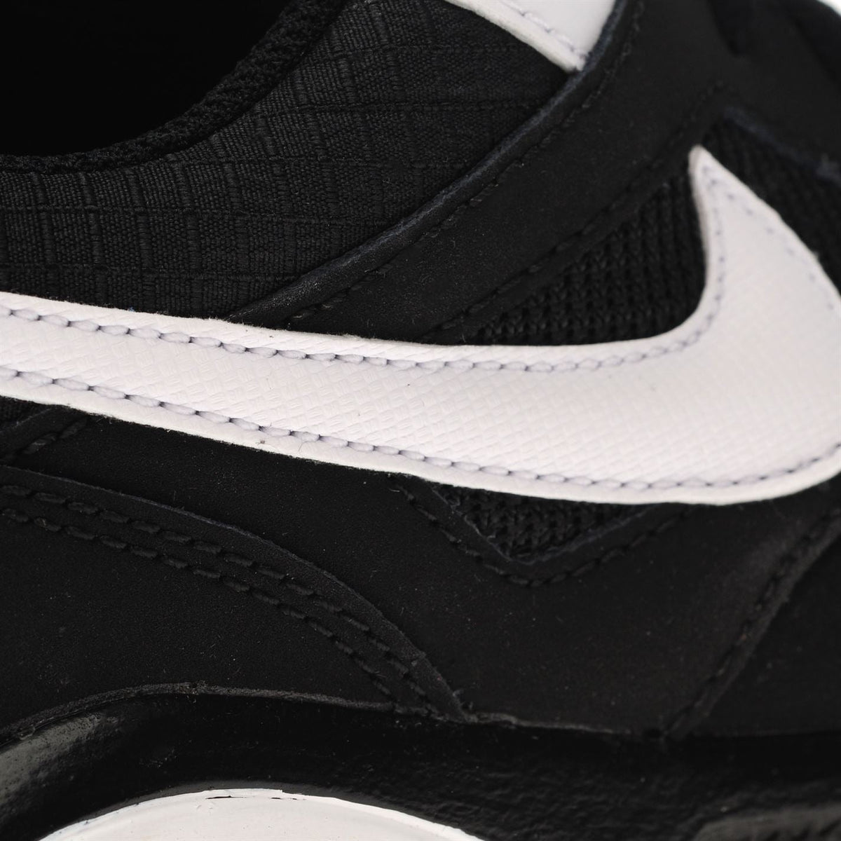 Black boys' Nike trainers with white midsole trim and stitched side panel