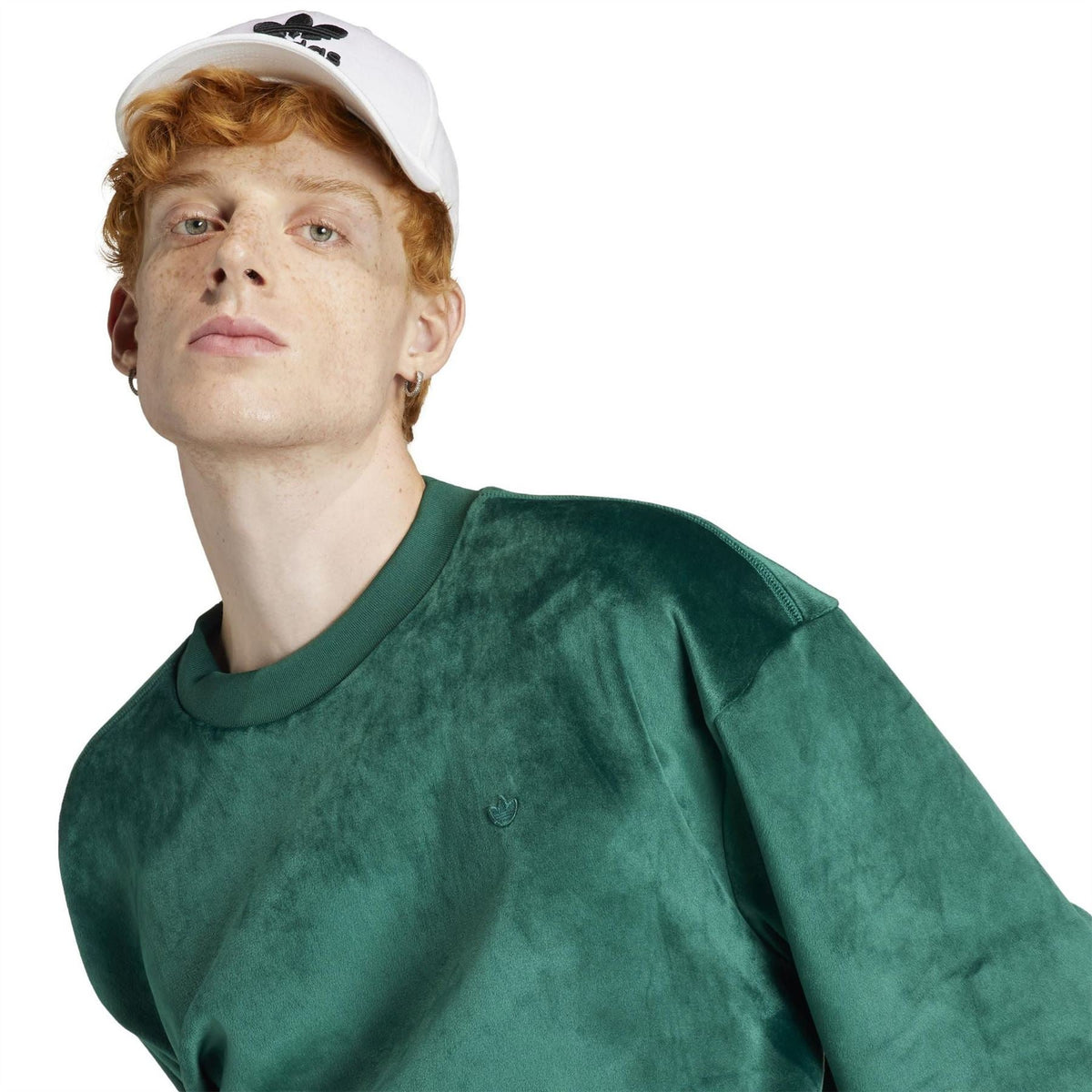 Green sweater close-up with crew neck and small logo at chest
