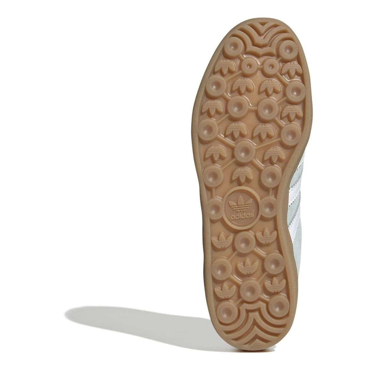Outsole of light aqua suede lace-up trainers with textured gum rubber tread pattern.