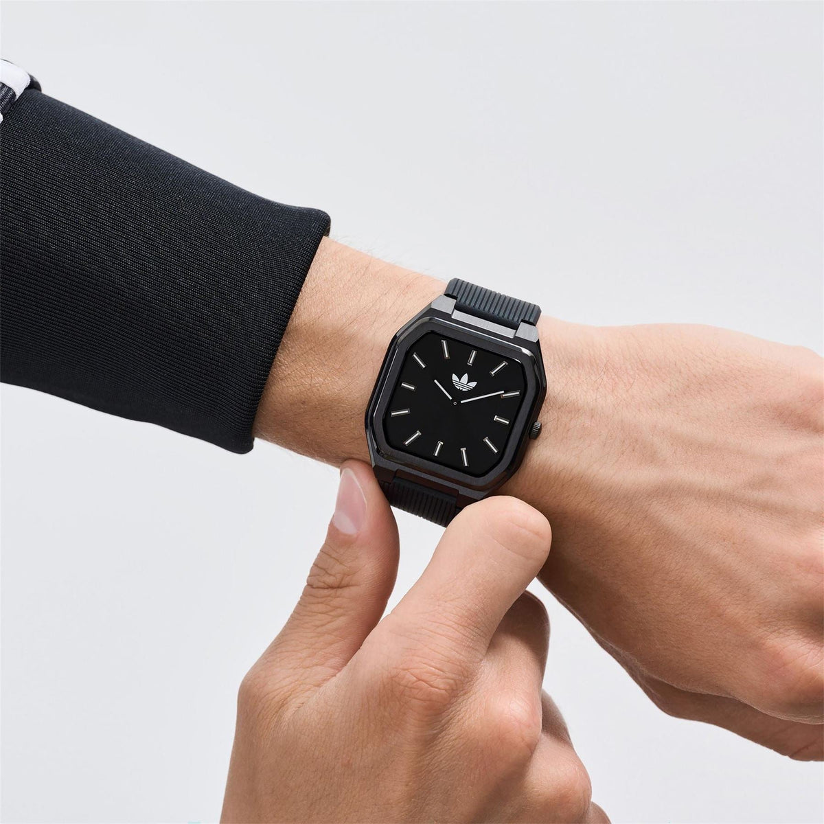 adidas Originals watch, black dial with silver-tone case and black ridged strap on wrist