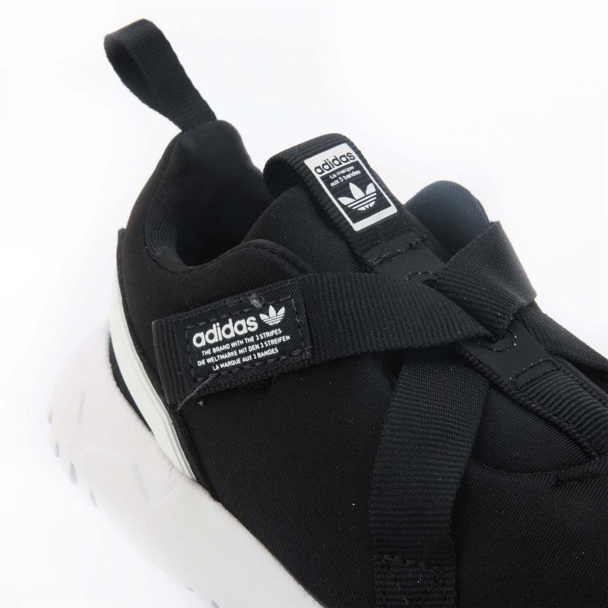 Black trainers close-up with adidas logo labels and hook-and-loop strap