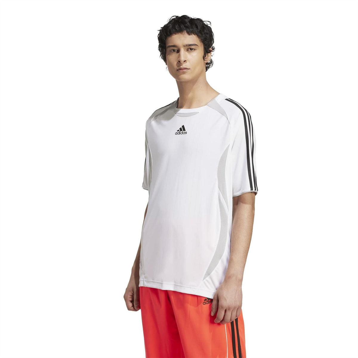 White adidas T-shirt with black side stripes, worn with red track pants