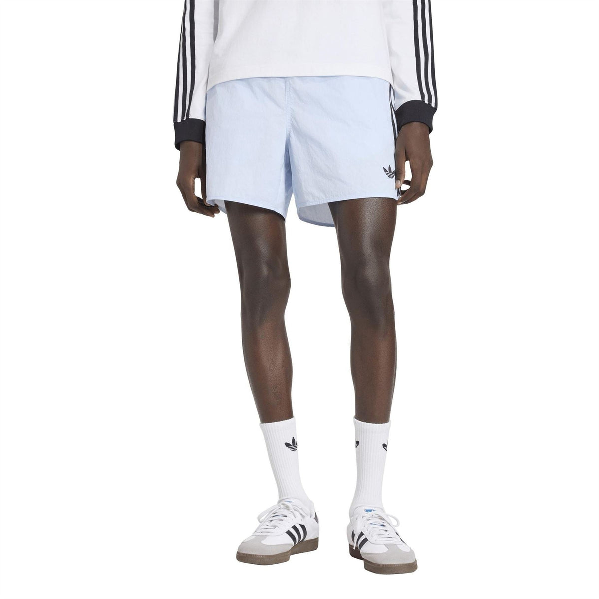 Light blue shorts on model, loose fit with elastic waist and side logo