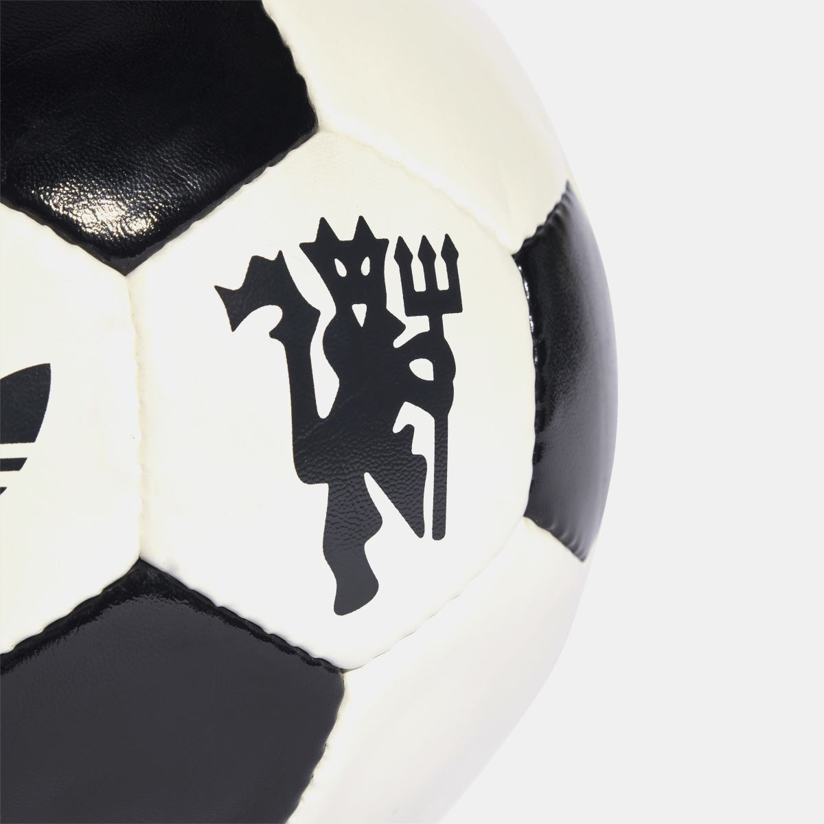 Close-up of off-white soccer ball panel with black club crest