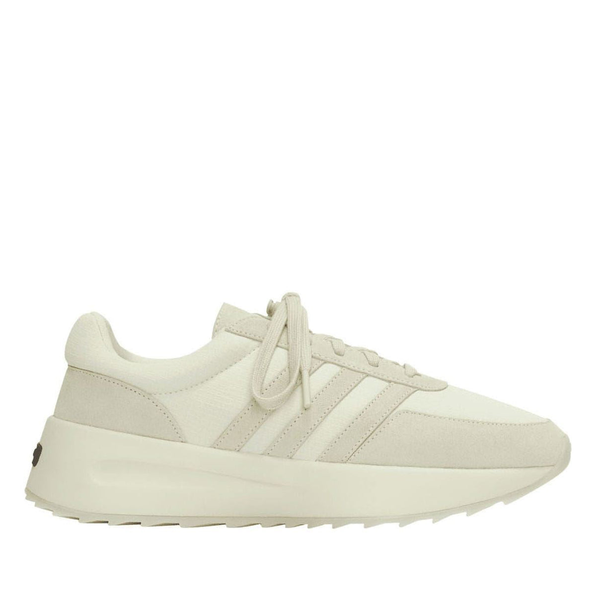 Cream lace-up trainers in side profile with three-stripe detailing