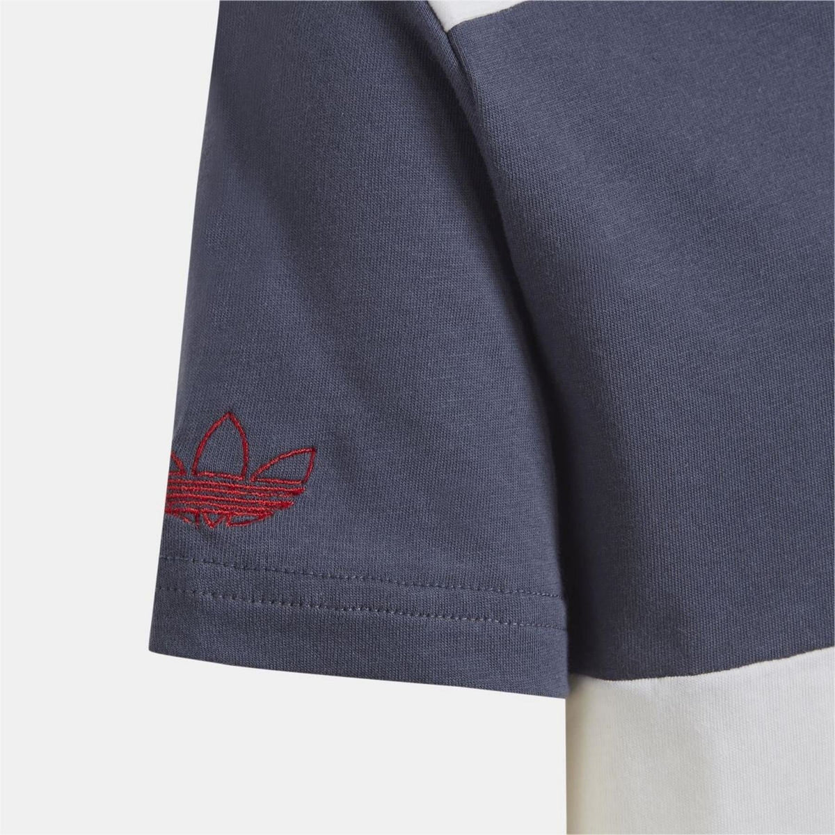 Close-up of navy adidas T-shirt sleeve with red trefoil logo and stitched hem