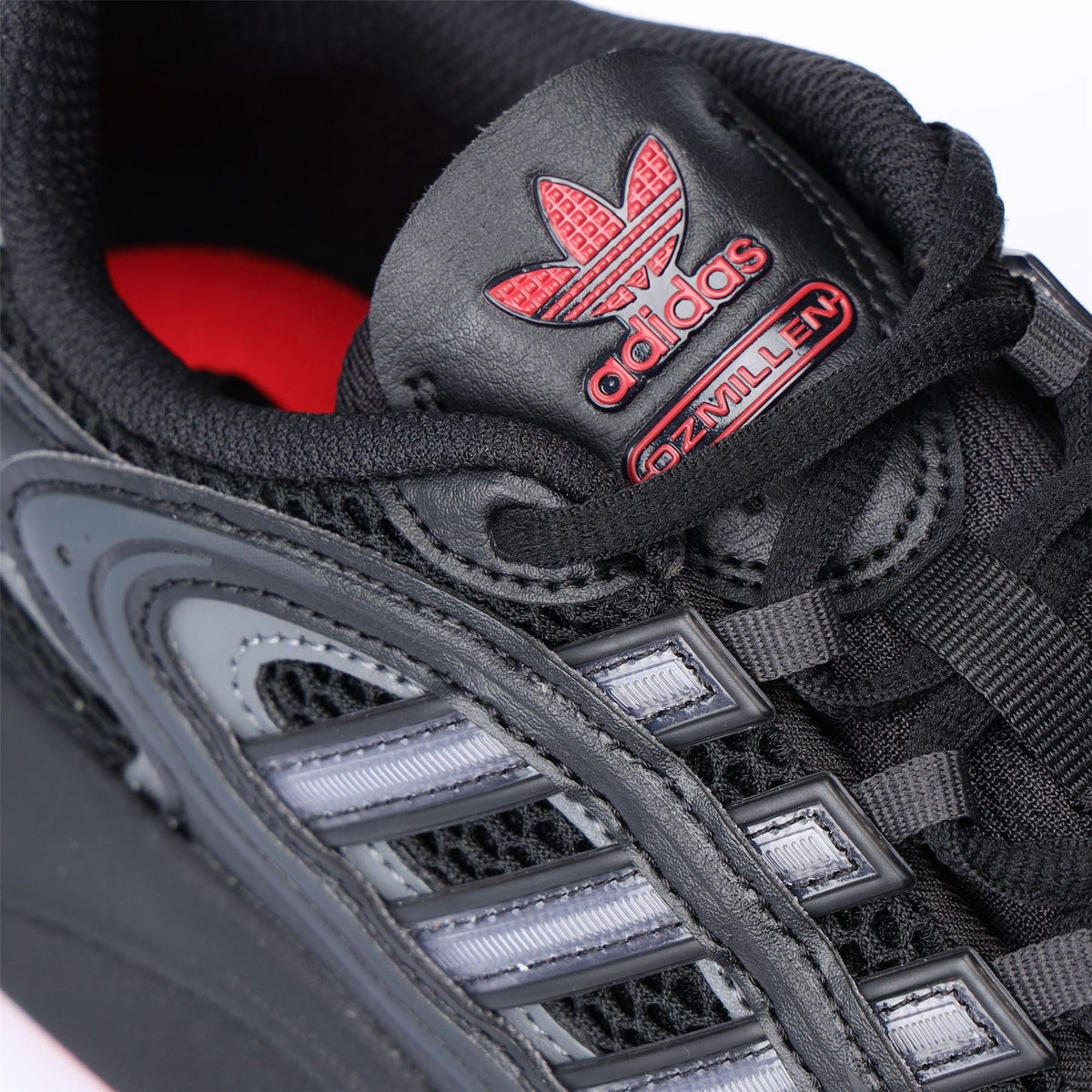 adidas Ozmillen tongue logo detail on black lace-up trainers