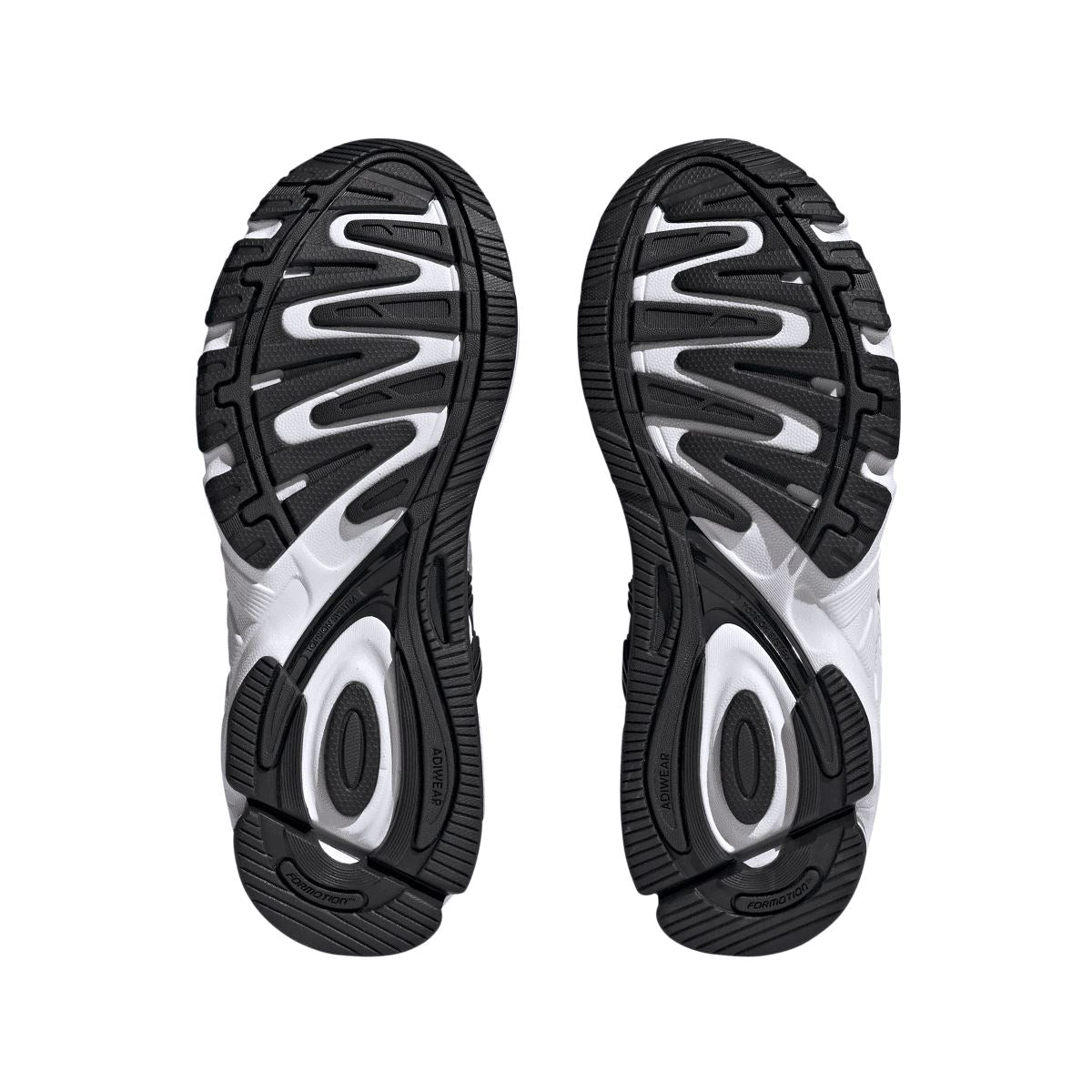 Trainers outsoles showing black traction tread with grey and white details