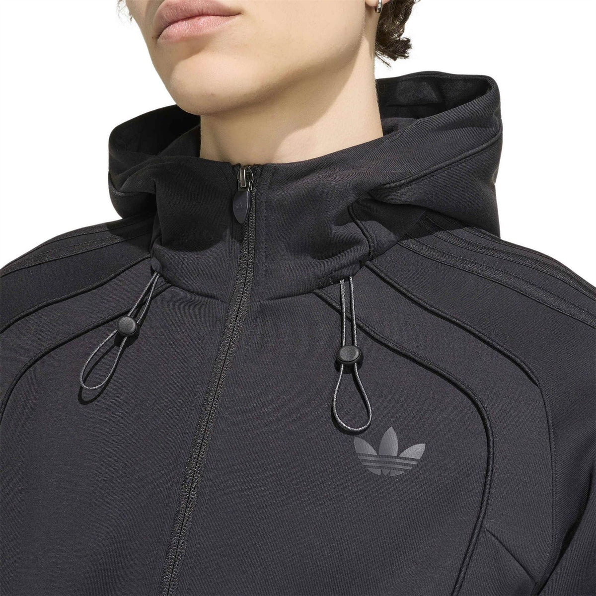 Black zip-up hoodie chest close-up with hood drawcords and adidas logo