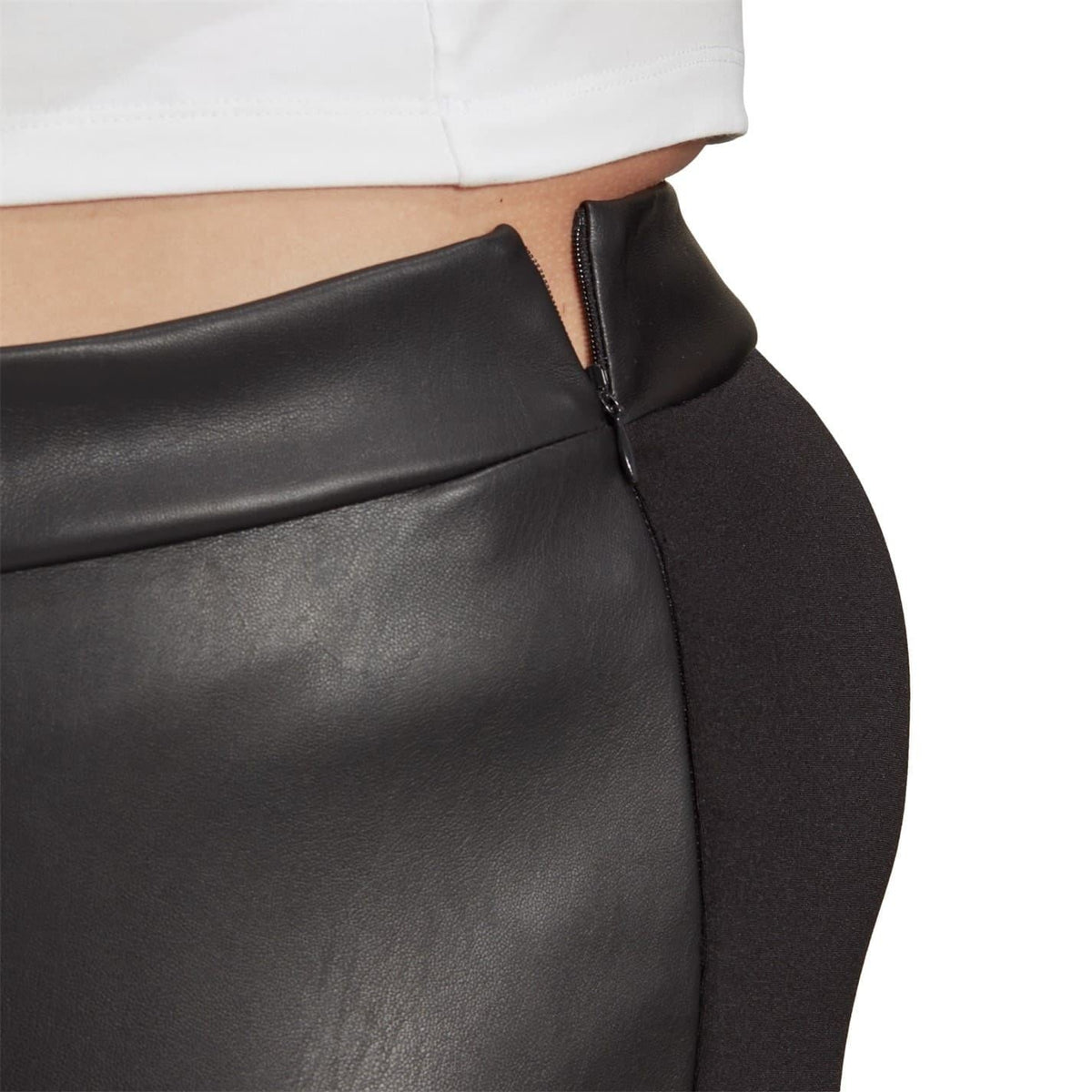 Close-up of black textured legging fabric with front snap placket and curved yoke seam