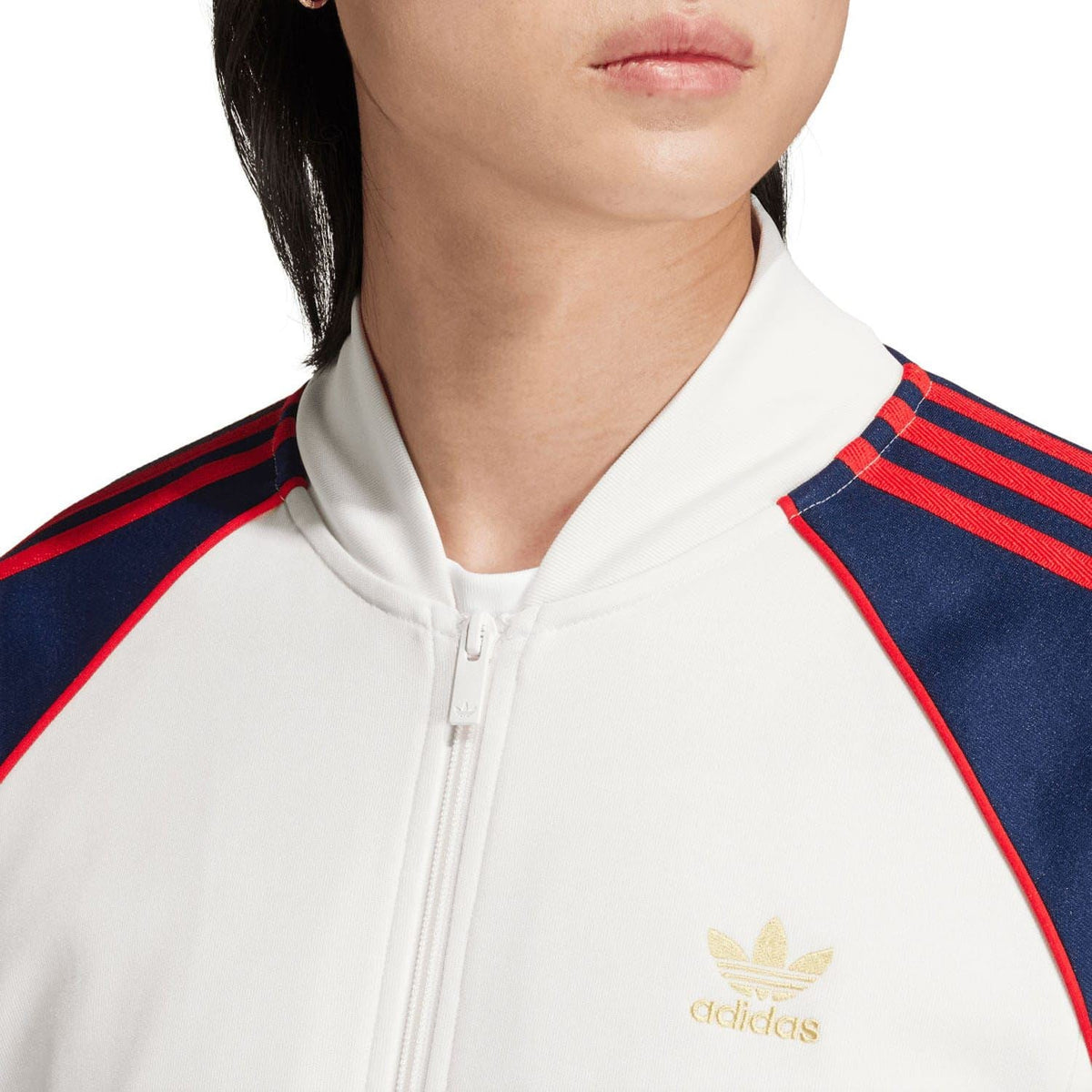 White track jacket collar and chest logo; navy shoulder stripes with red detailing