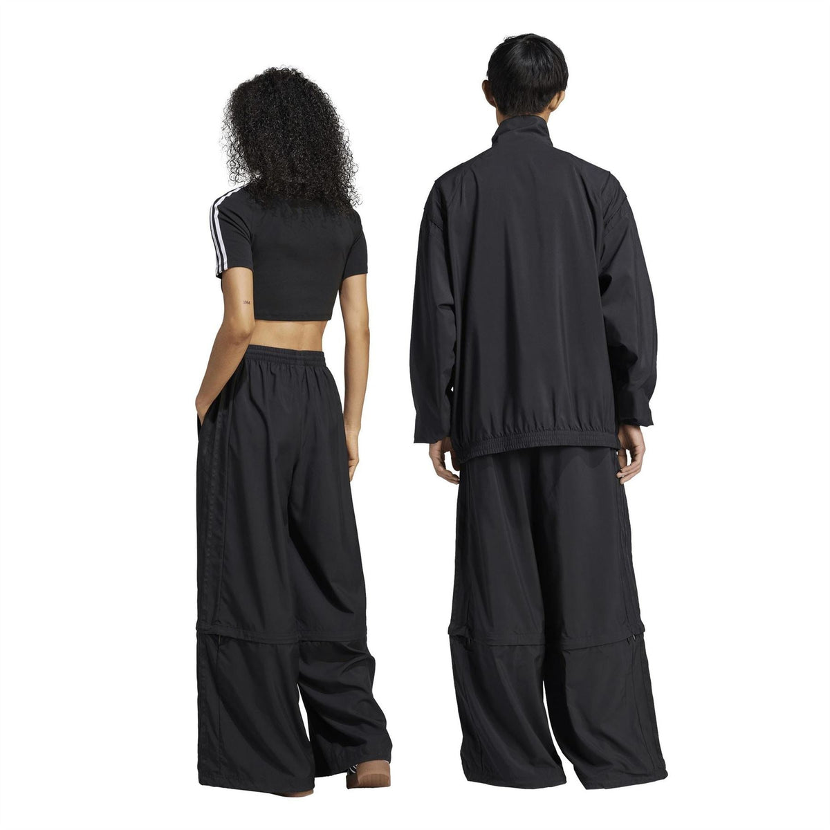 Black wide-leg track pants from behind with elastic waistband and stitched seam panels.