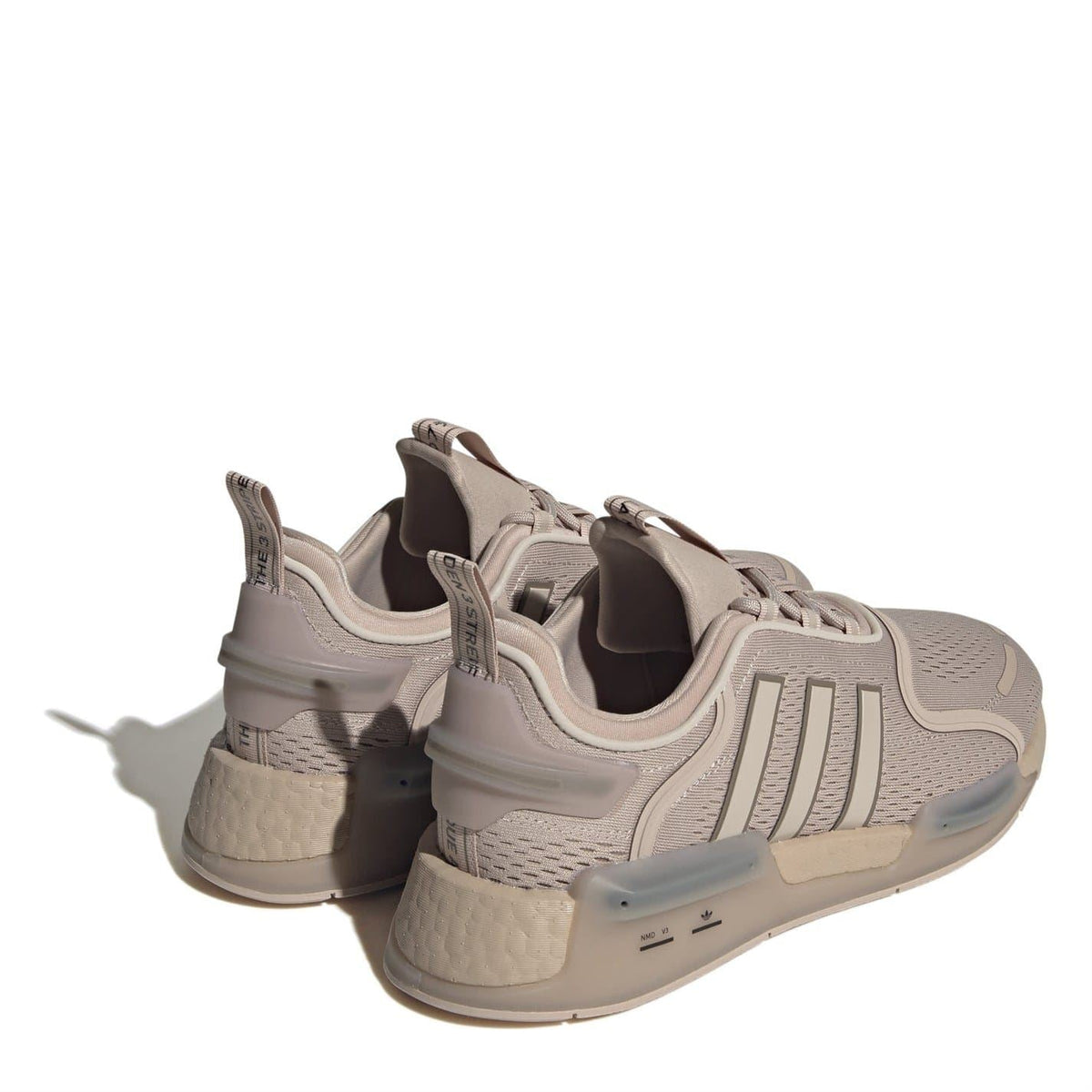 Beige NMD V3 low-top sneakers showing rear heel pods and cushioned collar
