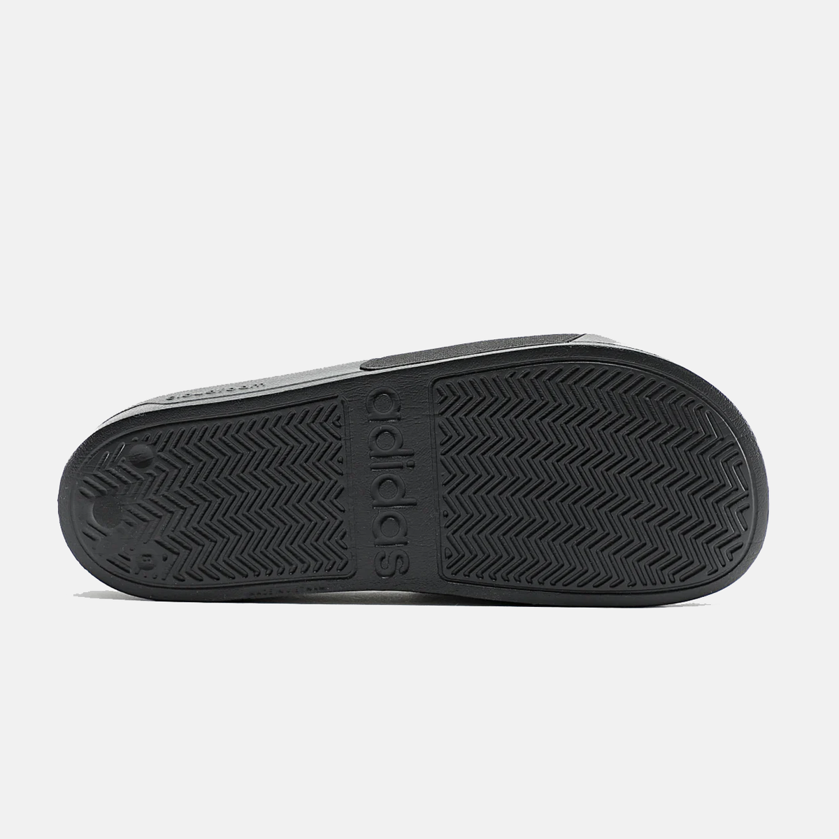 Black adidas slide sandal outsole with adidas logo and chevron tread