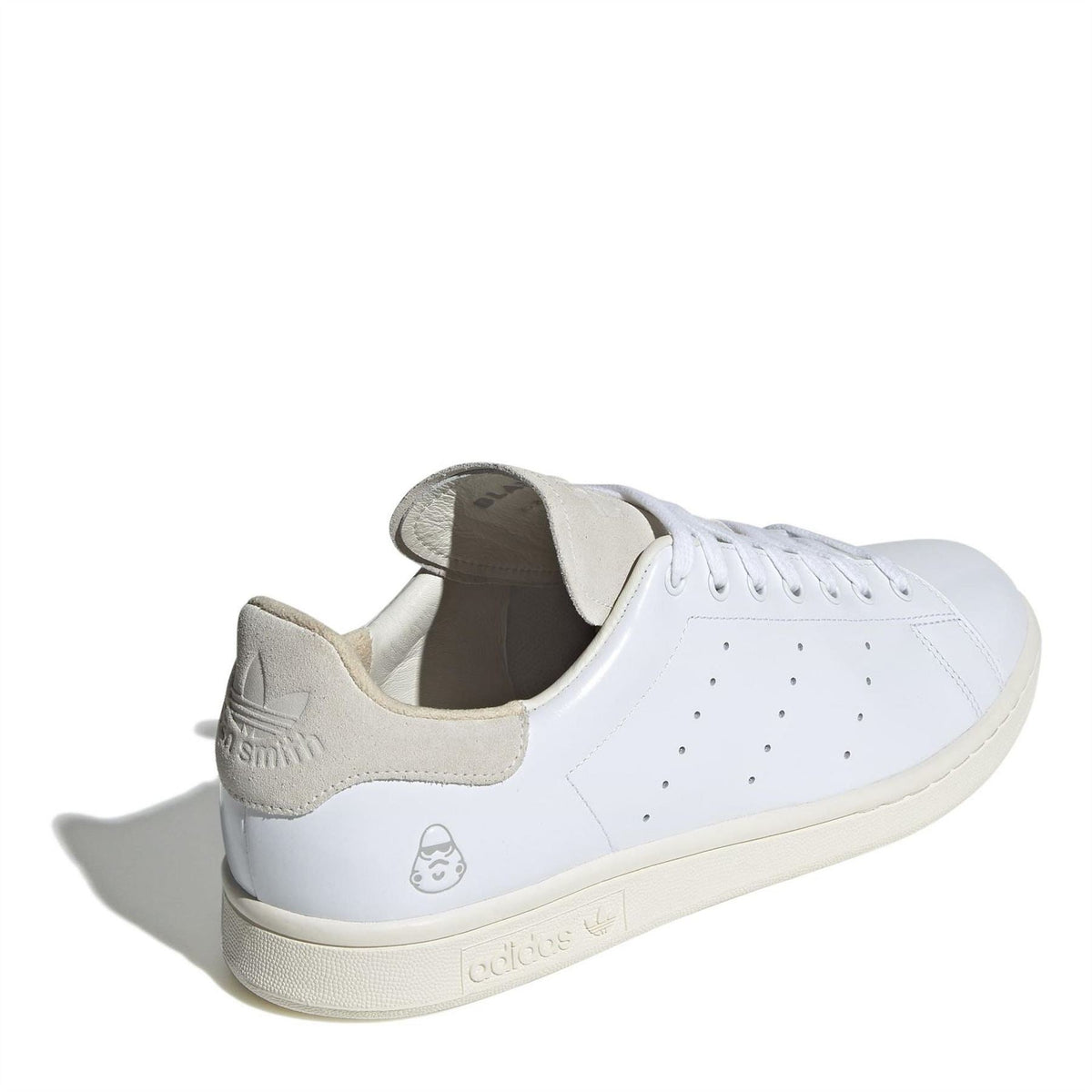 White low-top sneakers with beige collar lining, heel shield graphic, and lace-up