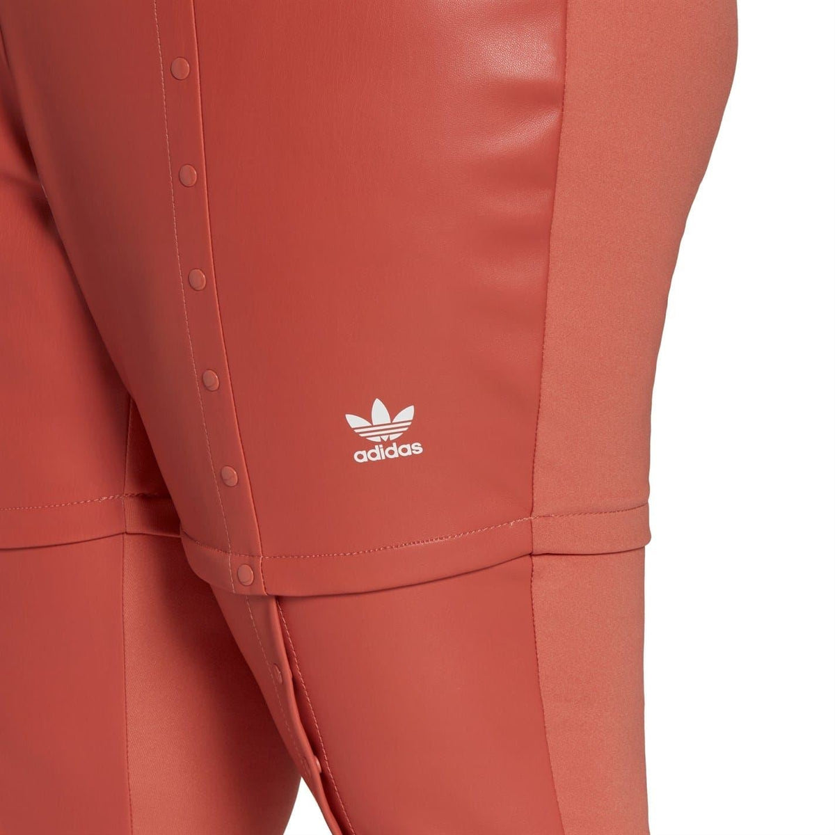 adidas jogger sweatpants detail, rust-red fabric with adidas logo and stitched seams