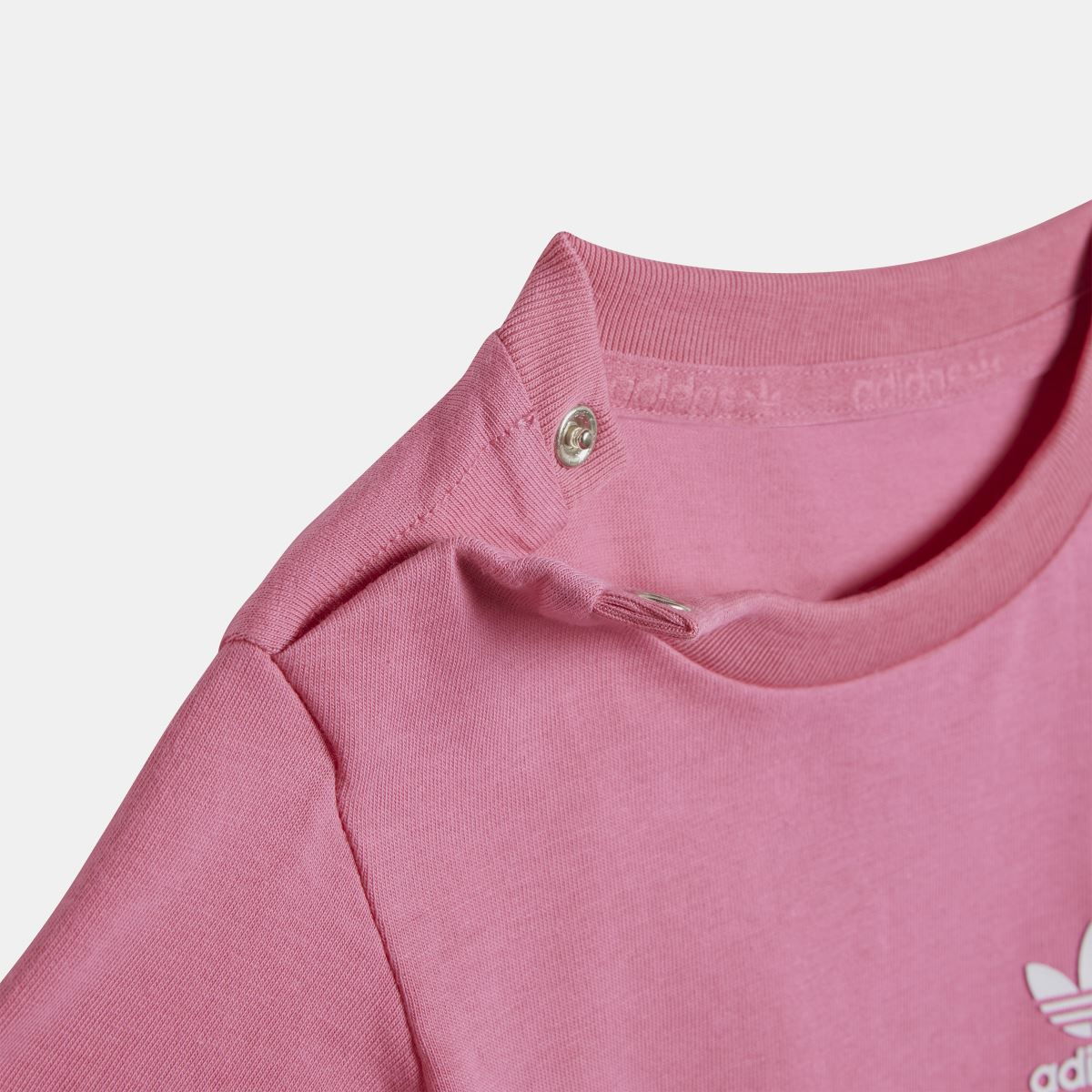 Infants pink T-shirt with ribbed crew neck and small snap detail at collar