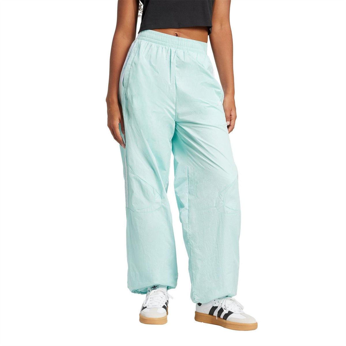 Light aqua windbreaker-style track pants with tapered legs and side stripes