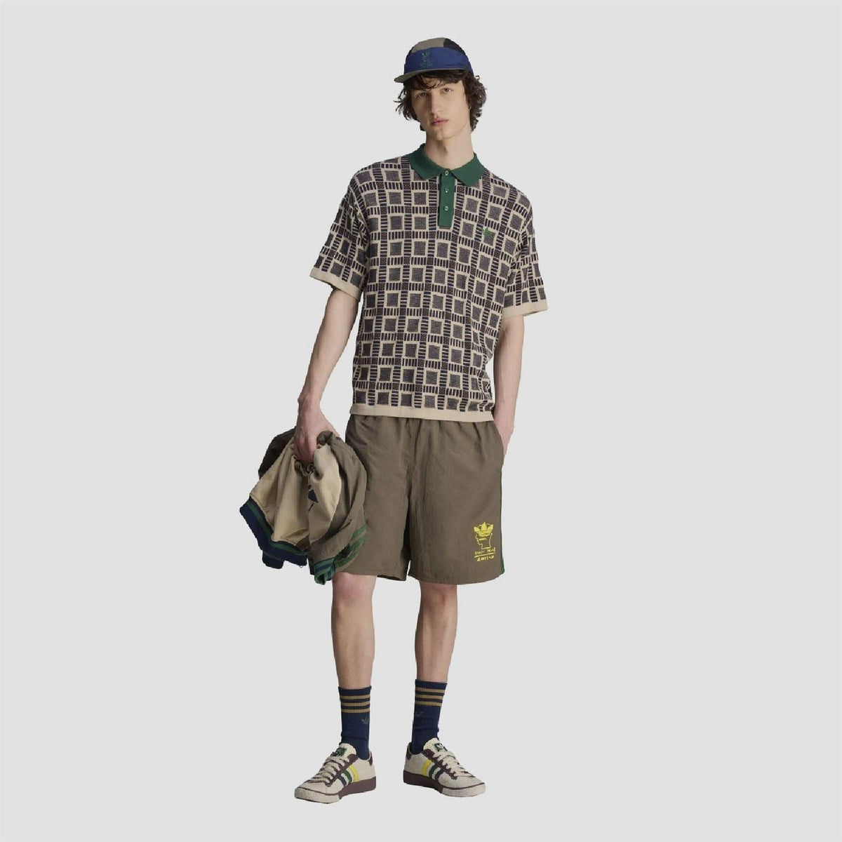 adidas Originals polo shirt on model: sand geometric pattern, green collar and buttons