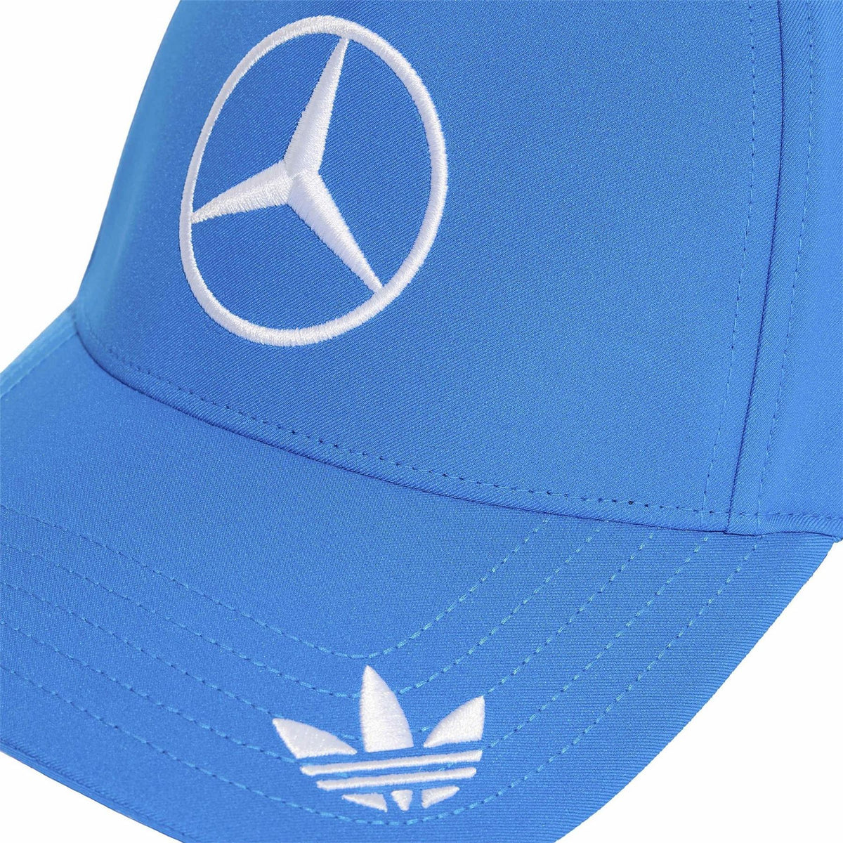 Blue snapback cap close-up with embroidered Mercedes circular logo and stitched brim