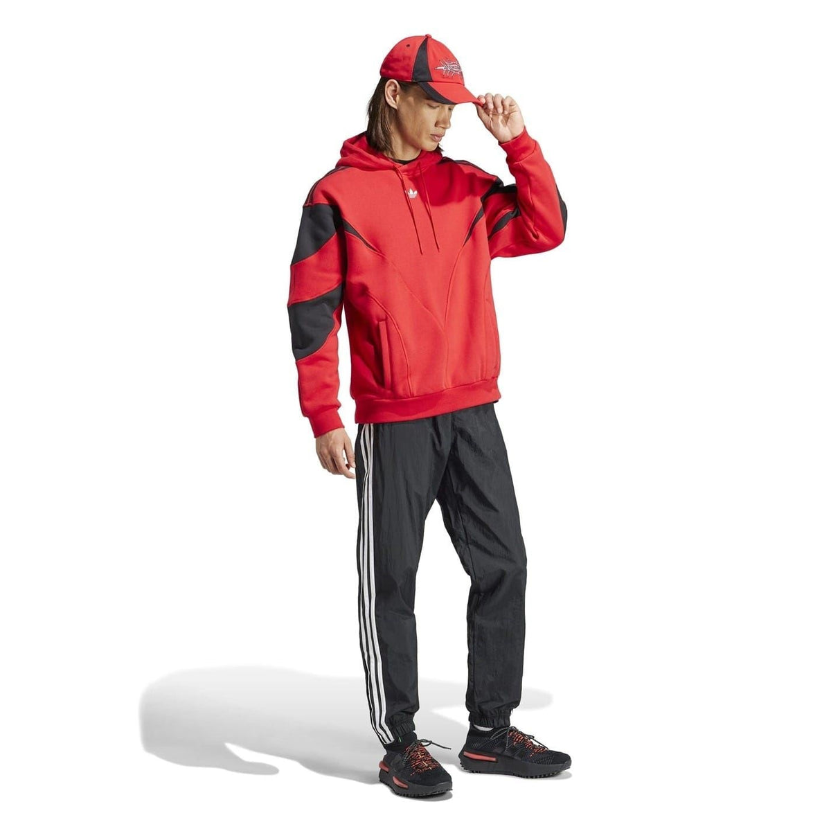 Red hooded sweatshirt with black sleeve panels and drawstring, worn with track pants.