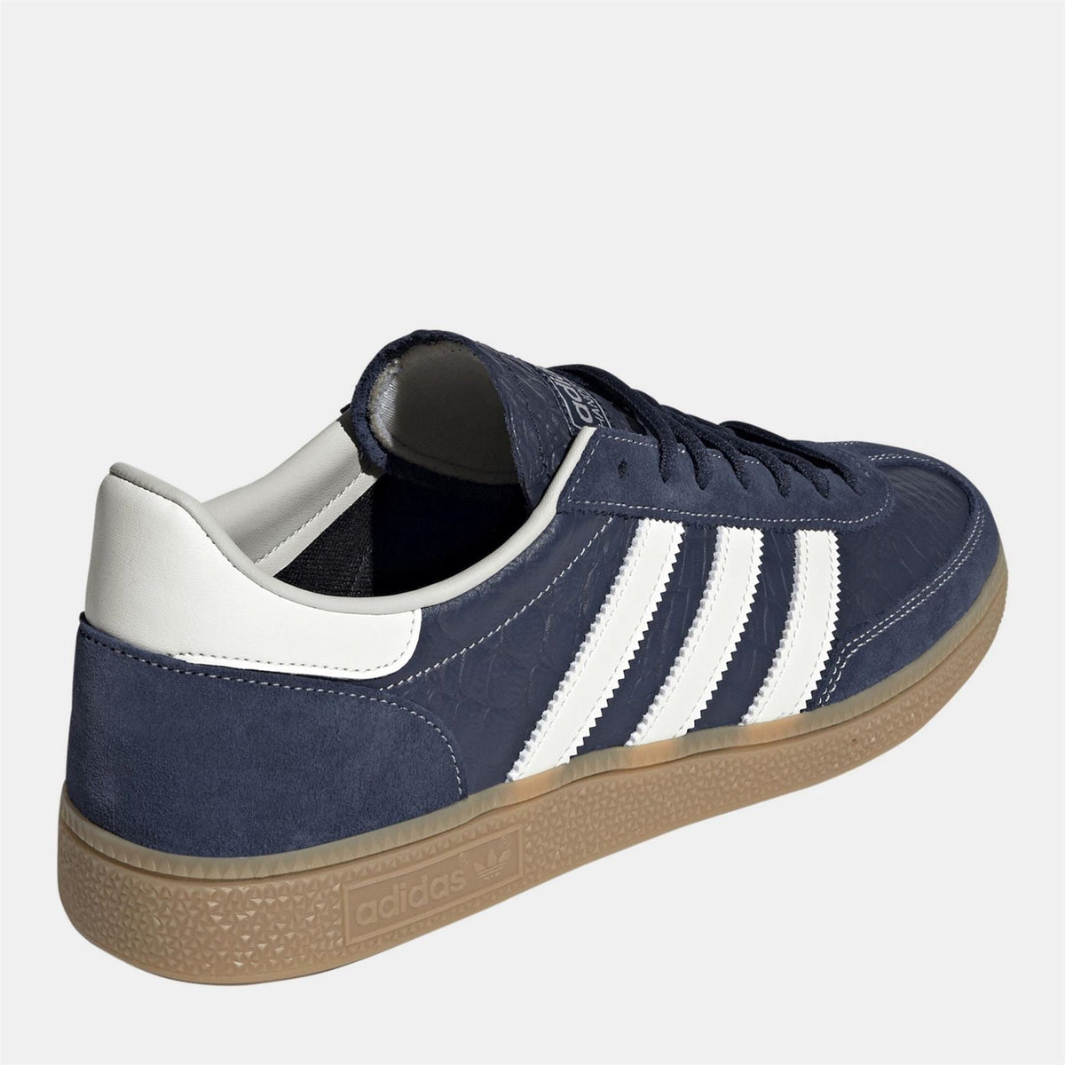 Navy adidas Spezial sneakers with white side stripes, pinkish heel lining, gum sole.