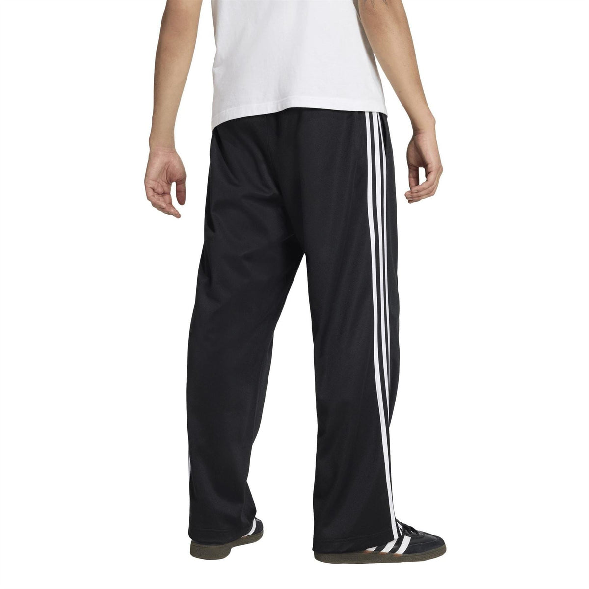 Black track pants with white vertical side stripes and relaxed, ankle-length cut