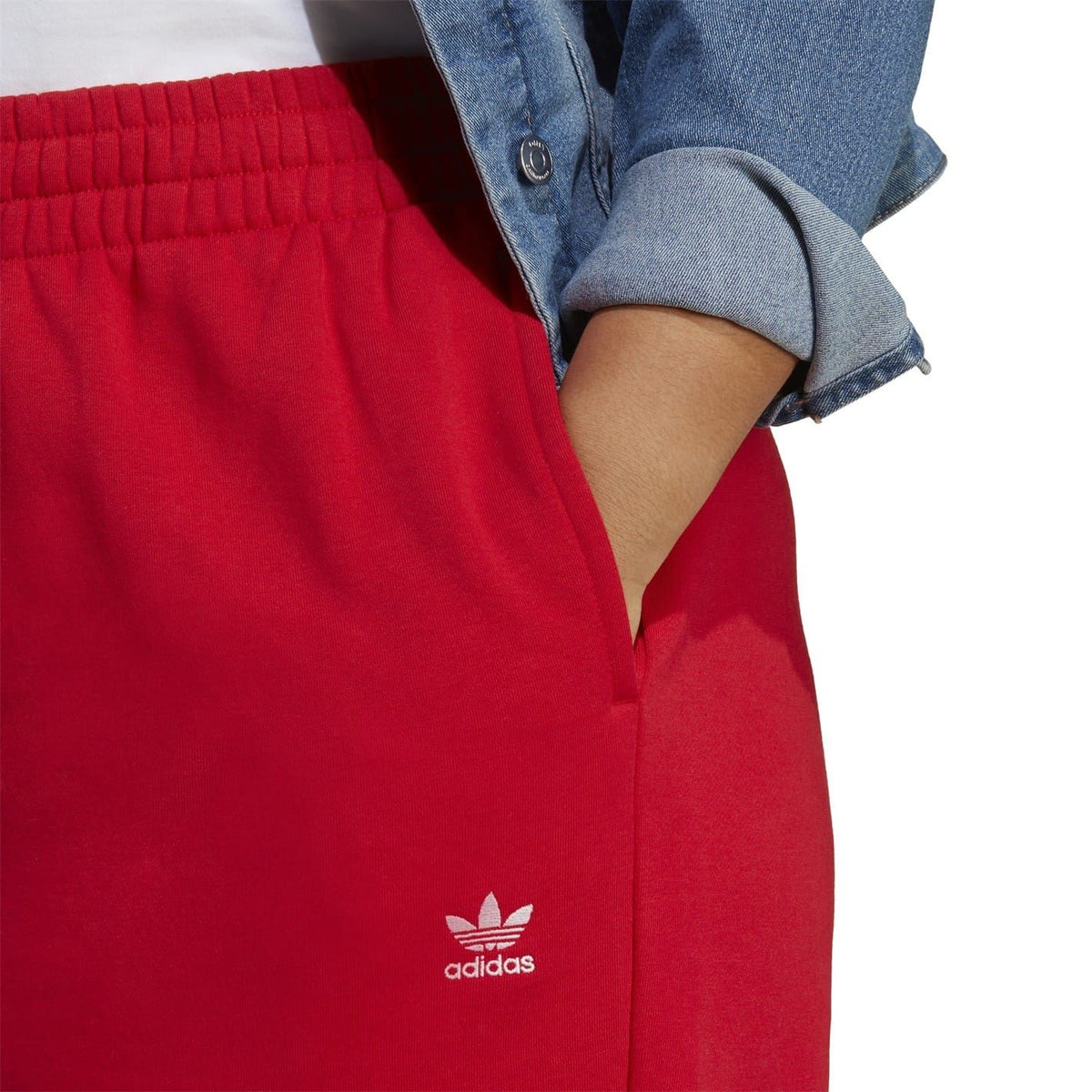Red joggers close-up with elastic waistband and adidas trefoil on leg