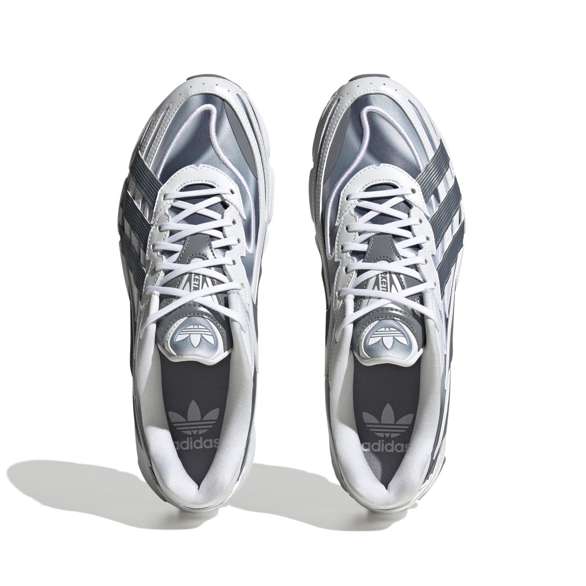 White and grey lace-up sneakers, top view of tongues and inner lining with Adidas logos