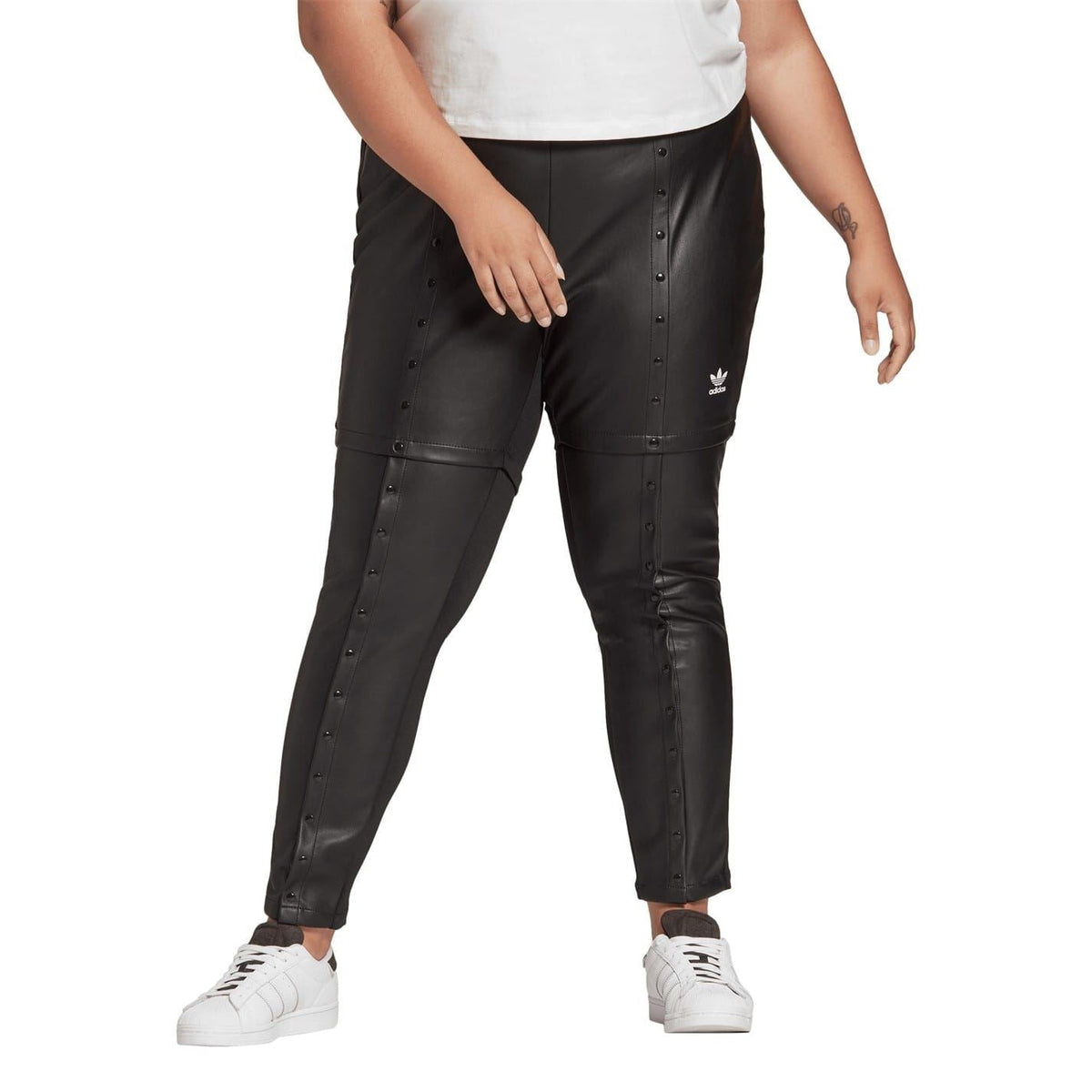 Black slim-fit legging pant with vertical snap rows and trefoil logo on thigh